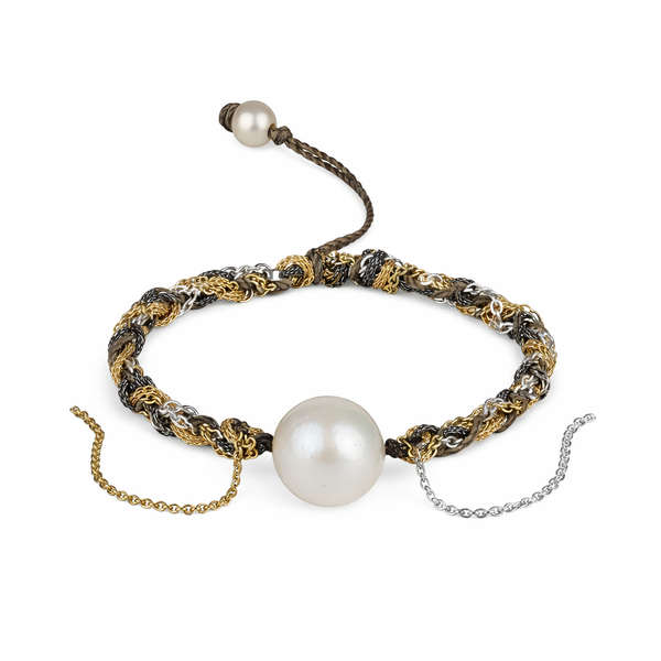 A bracelet featuring a round freshwater pearl centerpiece, surrounded by gold and silver plated chains.