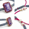 Multicolor woven bracelet with emerald-cut light-purple amethyst and ruby-red halo on adjustable cord