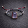 Multicolor woven bracelet with emerald-cut light-purple amethyst and ruby-red halo on adjustable cord