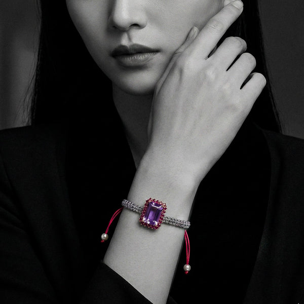 Multicolor woven bracelet with emerald-cut light-purple amethyst and ruby-red halo on adjustable cord