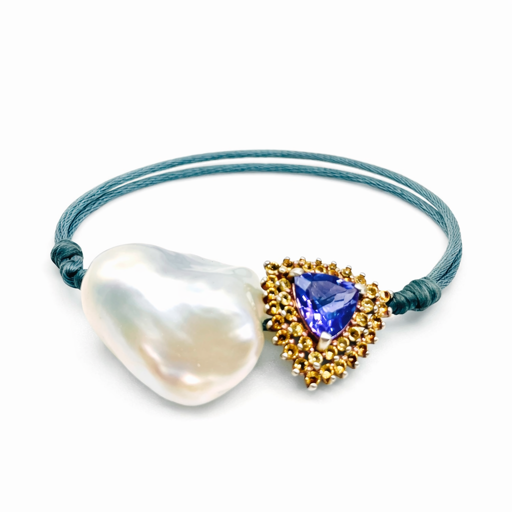 Jewelry with a heart-shaped pearl and gold and blue gemstone on a white background