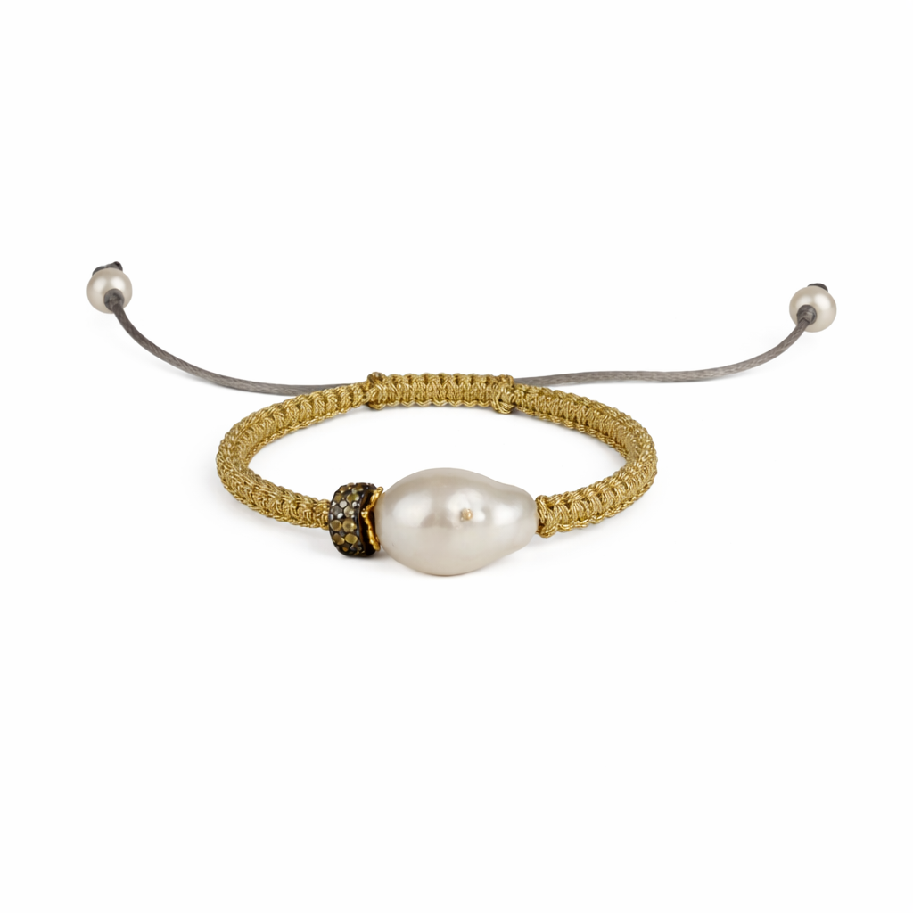 A bracelet featuring a large baroque freshwater pearl with a white topaz top, surrounded by grey-colored satin thread and gold-plated finishes.