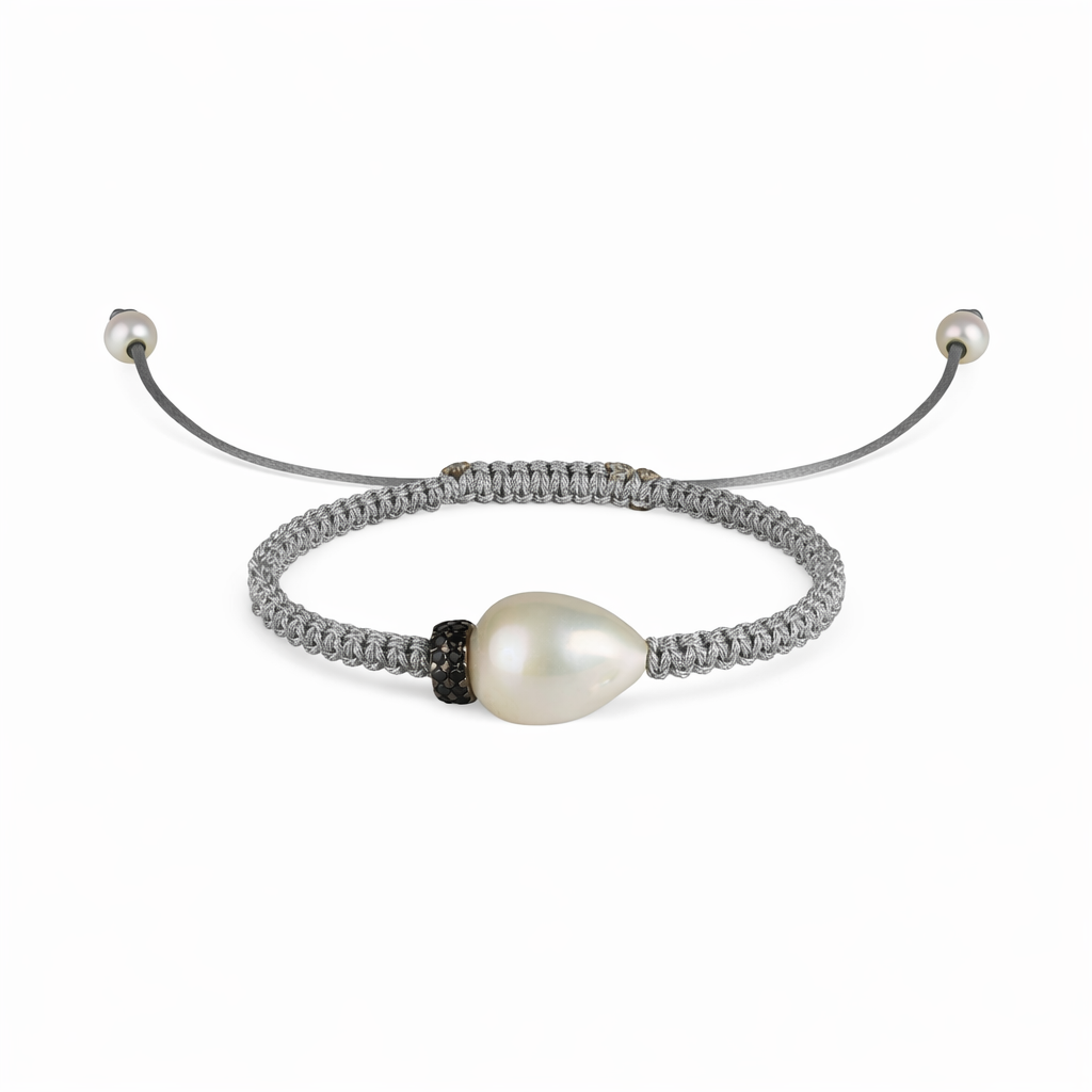 A light gray macramé bracelet with a baroque freshwater pearl and a blue sapphire spinning top, with gold-plated finishes and silver accents.