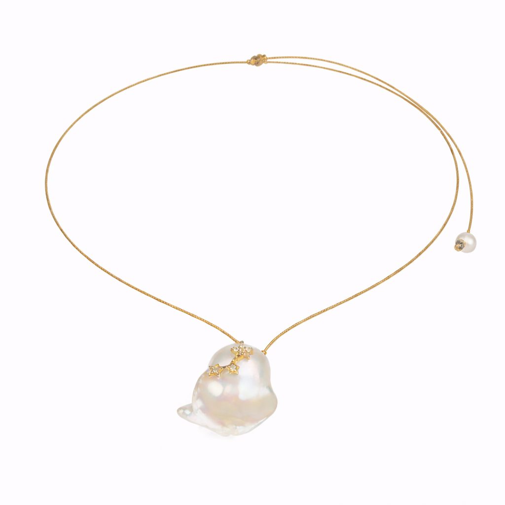 Gold necklace with a large pearl pendant on a white background