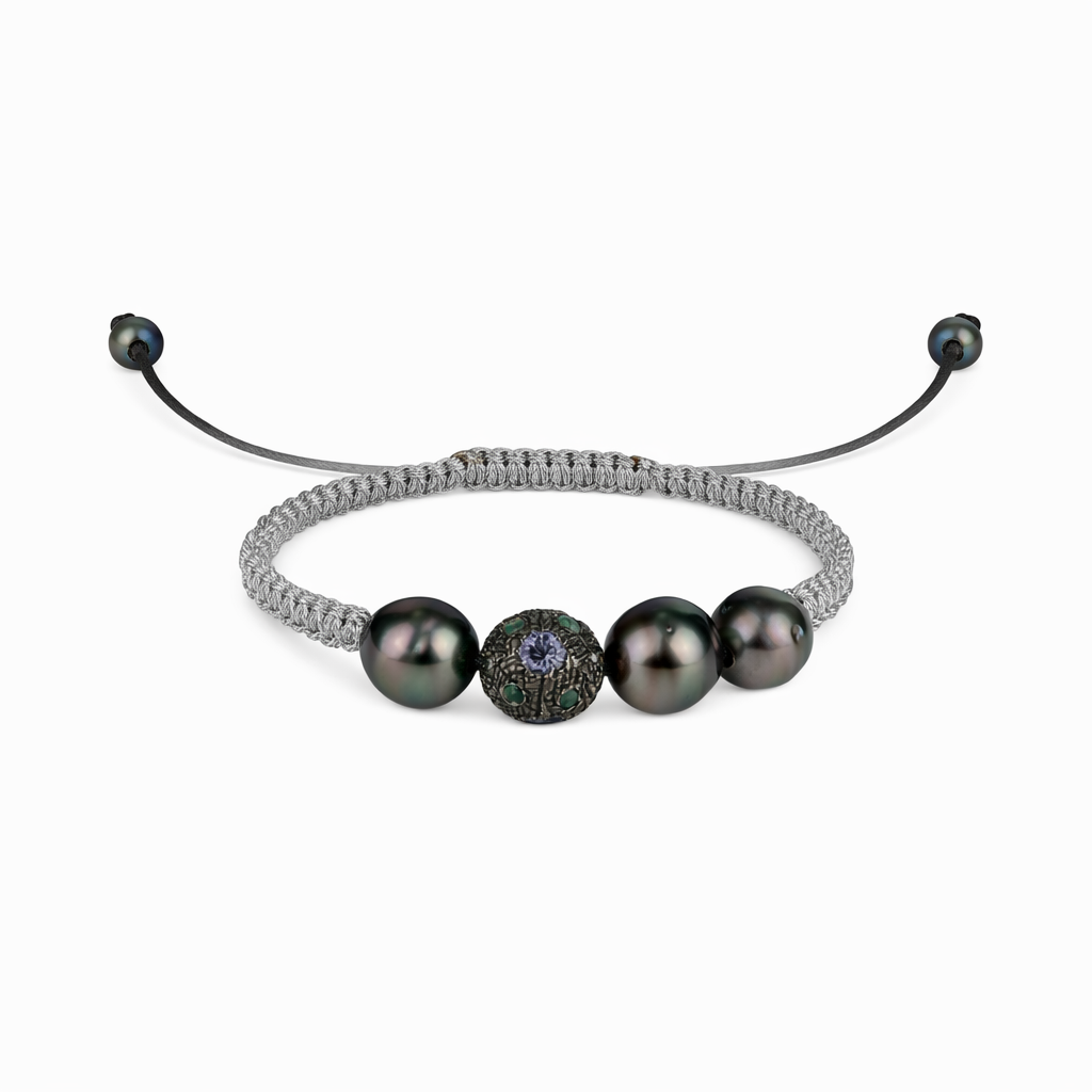 A light gray silver macramé bracelet with three Tahitian pearls and multicolored semiprecious stones, featuring a ball of multicolored stones and a leather loop.