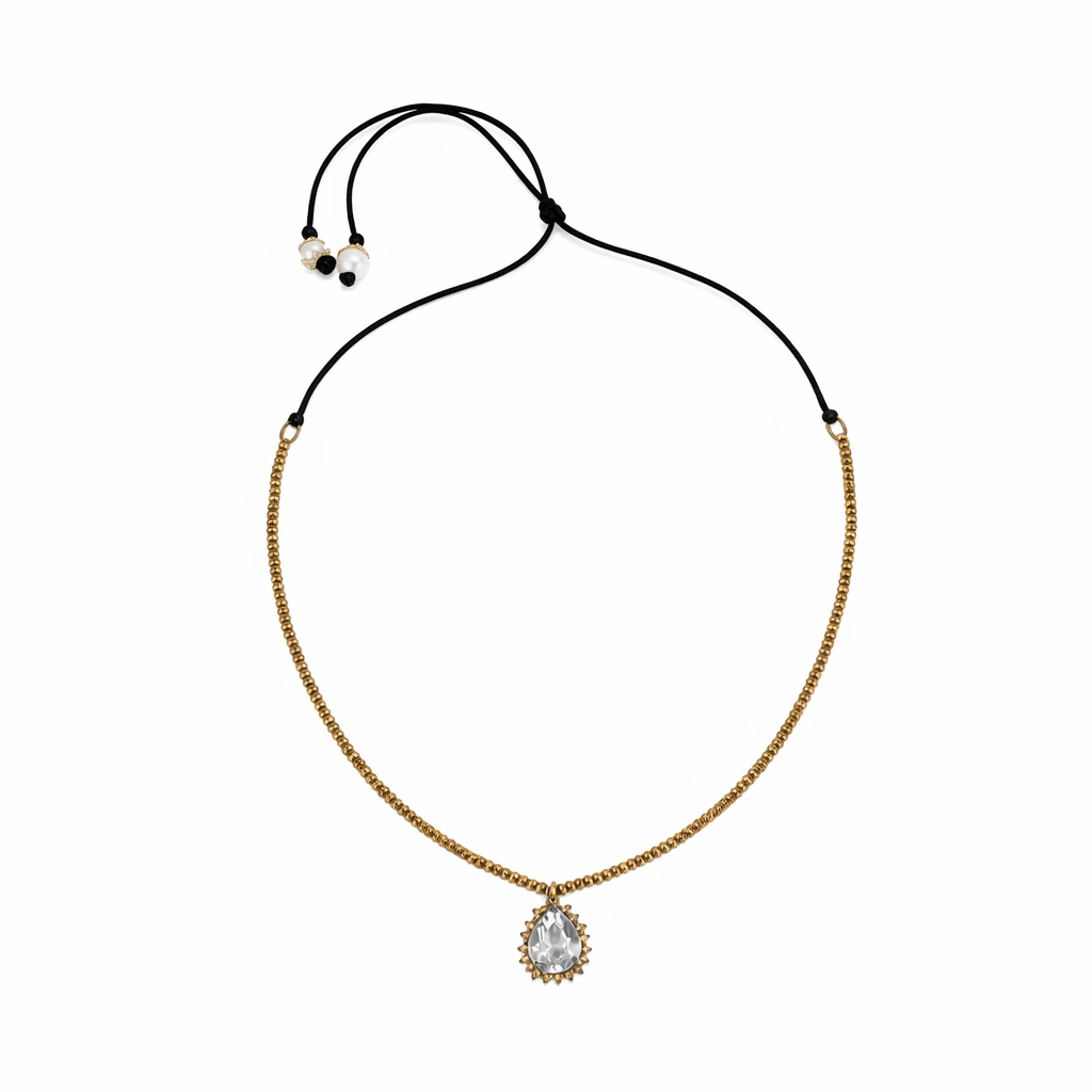 Gold necklace with a clear pendant on a white background