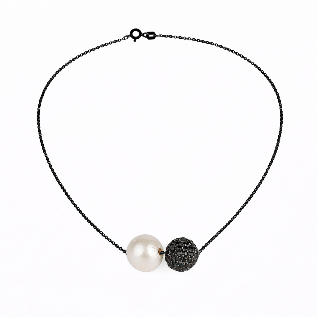 Necklace with a pearl and black bead on a white background