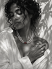 Long baroque pearl necklace doubled at collarbone length, garnet ornament in deep red at center, worn on a model in white linen, Mediterranean light
