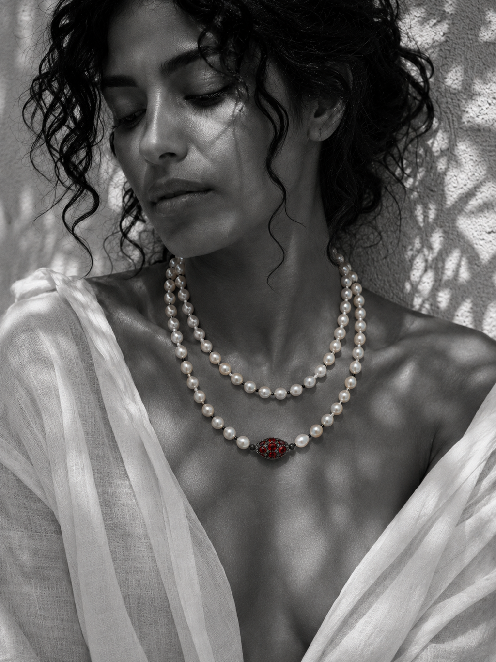 Woman wearing Adele long pearl necklace doubled at the throat with red gemstone centerpiece — JLL Pearl