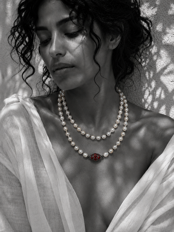 Woman wearing Adele long pearl necklace doubled at the throat with red gemstone centerpiece — JLL Pearl