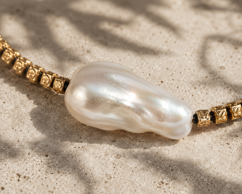 Macro detail of Arabelle necklace, baroque pearl with engraved gold cube beads on black thread — JLL Pearl