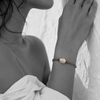 Black and white portrait of a baroque pearl bracelet on knotted cord against a stone wall — JLL Pearl