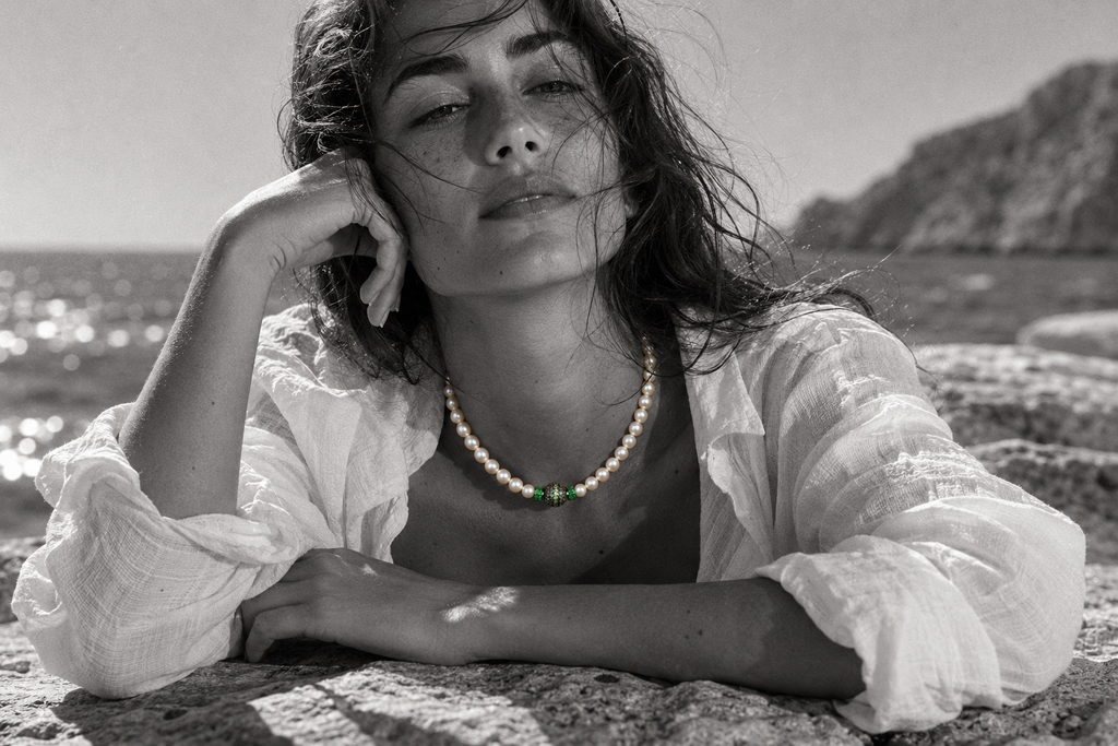 Bao freshwater pearl necklace peridot diopside worn by a woman lying on a rock by the Aegean Sea, black and white editorial photograph with selective color on jewelry, JLL Pearl