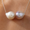 Bocca macro detail, two baroque freshwater pearls on warm skin, cream champagne and lavender-mauve iridescent, on fine 925 silver chain, handmade by JLL Pearl in Greece