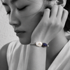 Black and white portrait of a baroque pearl bracelet with a pavé sapphire bead against the cheek — JLL Pearl