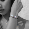 Black and white portrait of a double baroque pearl bracelet on dark braided cord — JLL Pearl
