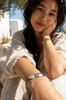 Butterfly macramé bracelet baroque grey pearls worn — Asian woman sitting, Greek village, natural Mediterranean light