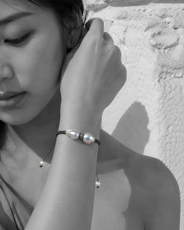 Butterfly macramé bracelet with baroque grey pearls — black and white portrait, Asian woman, Greek stone wall