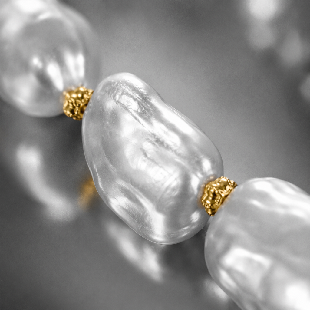 Close-up of Eden baroque pearl gold flower choker, ornate gold-plated flower caps glowing in warm gold against black and white baroque pearls, filigree detail visible, extreme shallow depth of field, JLL Pearl
