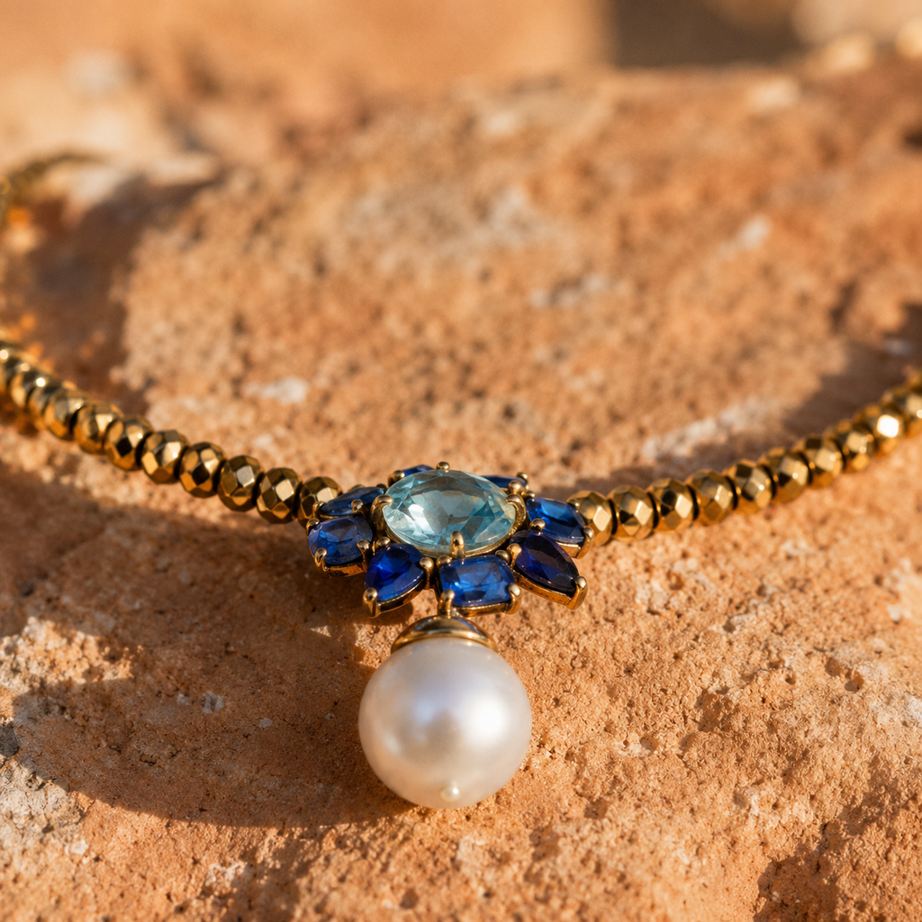 Close-up of Flowerdream freshwater pearl hematite topaz necklace pendant — aqua blue topaz, blue sapphires, 12mm white pearl drop on gold faceted hematite beads, handmade by JLL Pearl