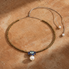 Flowerdream freshwater pearl hematite topaz necklace laid on warm terracotta stone, gold hematite beads, blue topaz and sapphire pendant, white pearl drop, lasso cord extended, handmade by JLL Pearl