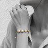 Black and white portrait of a triple pearl bracelet on braided gold cord — JLL Pearl