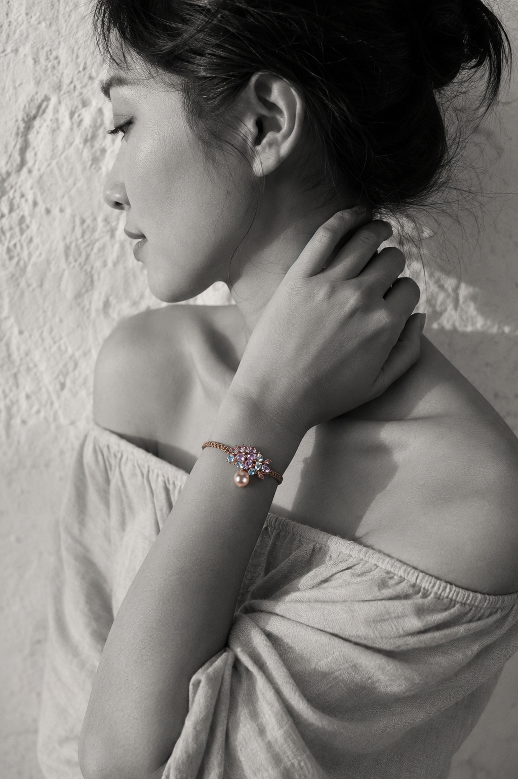 Karla bracelet by JLL Pearl — black and white portrait of an East Asian woman, selective colour on the sandy macramé cord, raw crystal cluster and hanging baroque blush-pink pearl