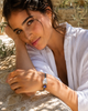 Woman wearing Kastos bracelet resting on stone table, baroque pearl and sapphire detail — JLL Pearl