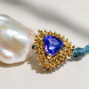 Macro detail of Kastos bracelet centerpiece, trillion-cut blue-violet sapphire in gold pavé setting — JLL Pearl