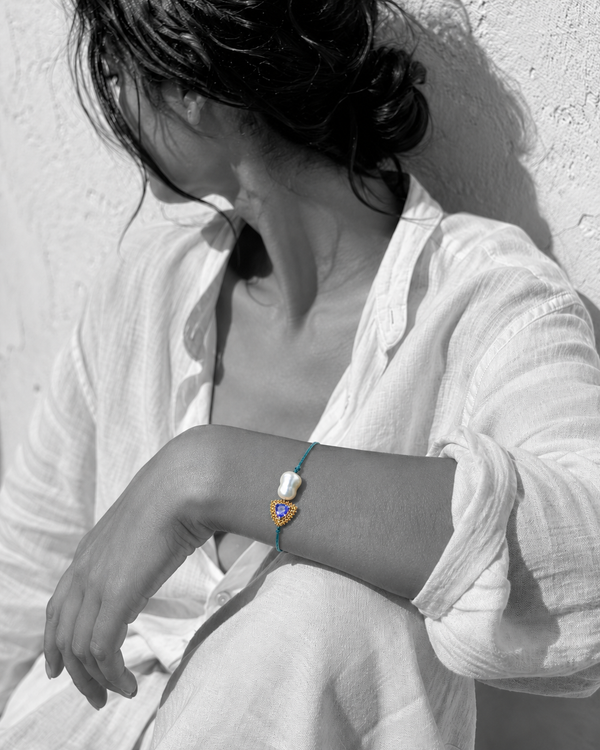 Woman wearing Kastos bracelet with baroque pearl and blue-violet sapphire gold centerpiece — JLL Pearl