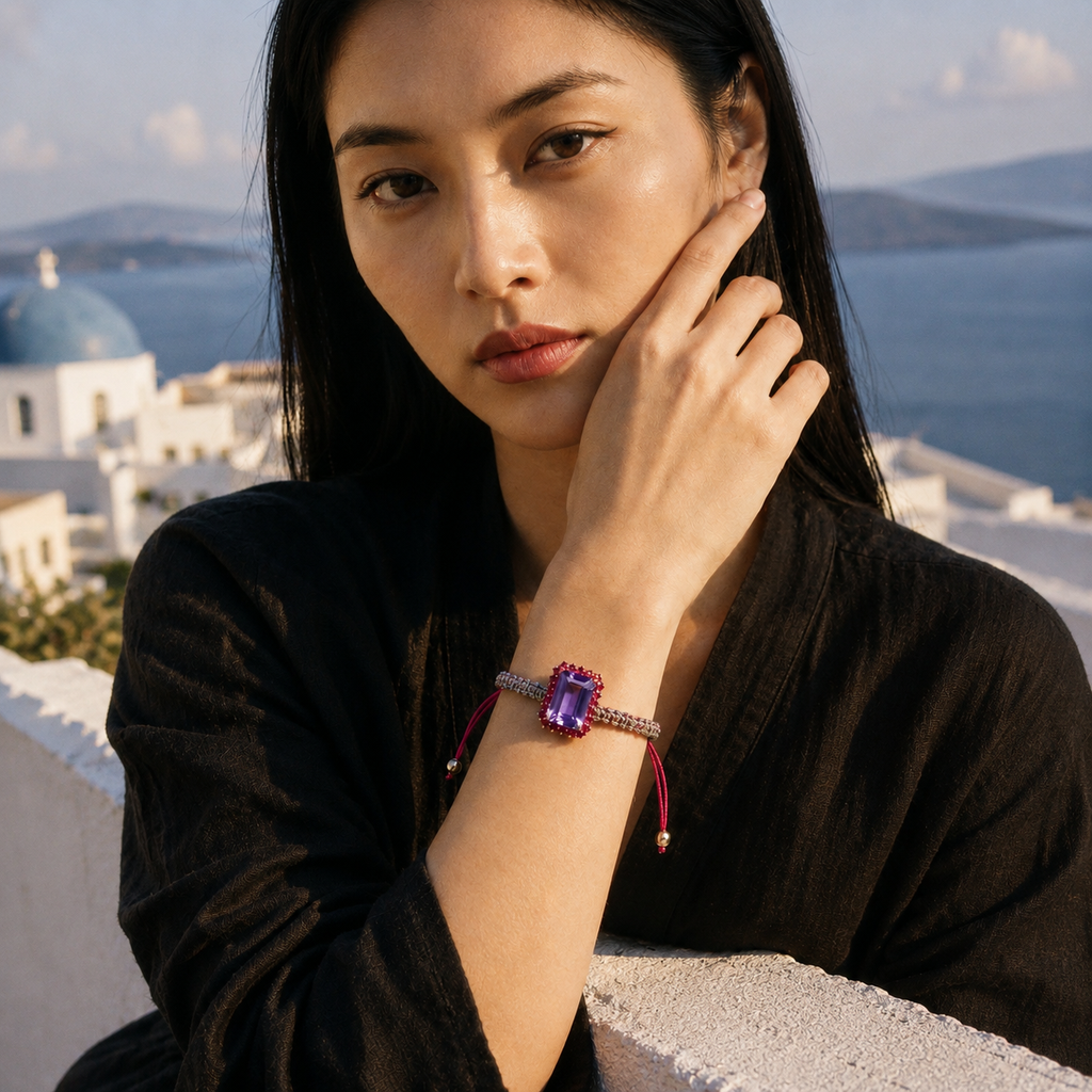 Kos amethyst topaz woven bracelet worn on wrist — lifestyle portrait on Santorini rooftop terrace, Aegean sea and white domes in background — JLL Pearl