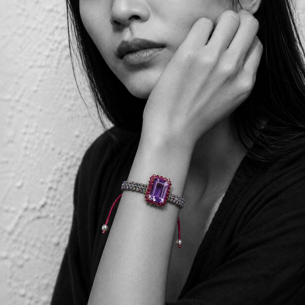 Kos amethyst topaz woven bracelet — black and white portrait, selective colour on pale lavender amethyst and pink topaz halo, Greek plastered wall — JLL Pearl
