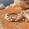 Three-strand pearl bracelet with oxidised silver star on a terracotta surface, Greek terrace