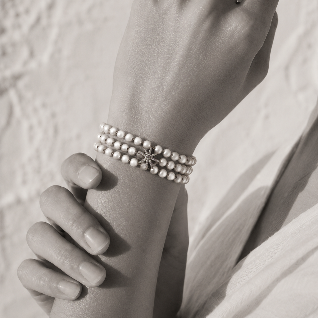 Black and white portrait of a triple-strand pearl bracelet with an eight-point diamond star charm — JLL Pearl