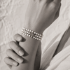 Black and white portrait of a triple-strand pearl bracelet with an eight-point diamond star charm — JLL Pearl