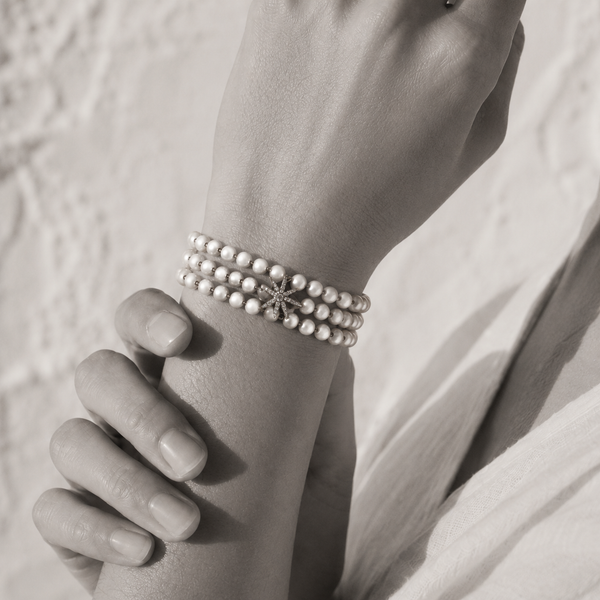 Black and white portrait of a triple-strand pearl bracelet with an eight-point diamond star charm — JLL Pearl