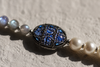 Close-up of Lola freshwater pearl labradorite necklace, oxidized silver oval connector set with sapphire fragments between 10mm white pearls and 6mm grey-blue labradorite beads, handmade by JLL Pearl