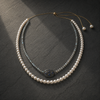 Lola freshwater pearl labradorite necklace laid on dark grey slate, two strands flowing from the oxidized silver oval connector set with sapphire fragments, handmade by JLL Pearl