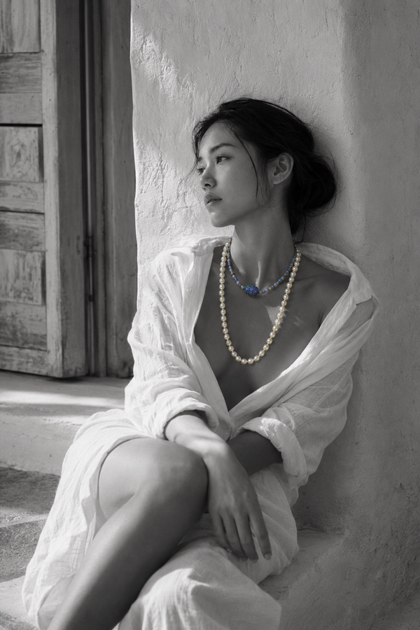 Lola freshwater pearl labradorite necklace worn by an Asian model seated near a Greek window, both strands on bare décolleté, oxidized silver connector in colour against black and white, handmade by JLL Pearl