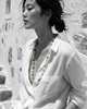 Miami baroque pearl necklace with tourmaline and labradorite worn by Asian model in profile, white linen shirt, whitewashed stone wall, wind in hair, natural colour necklace on black and white image, handmade by JLL Pearl