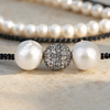 Close-up of Mina necklace centre piece: two baroque pearls flanking a pavé white topaz ball on black spinel strand