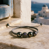 Paros Tahitian pearl macramé bracelet resting on marble windowsill, blue shutter and Aegean sea in background