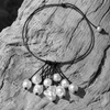 Peipei baroque pearl cluster necklace arranged on sun-bleached driftwood, multiple baroque freshwater pearls hanging from a central grey satin knot, black and white flat lay, handmade by JLL Pearl