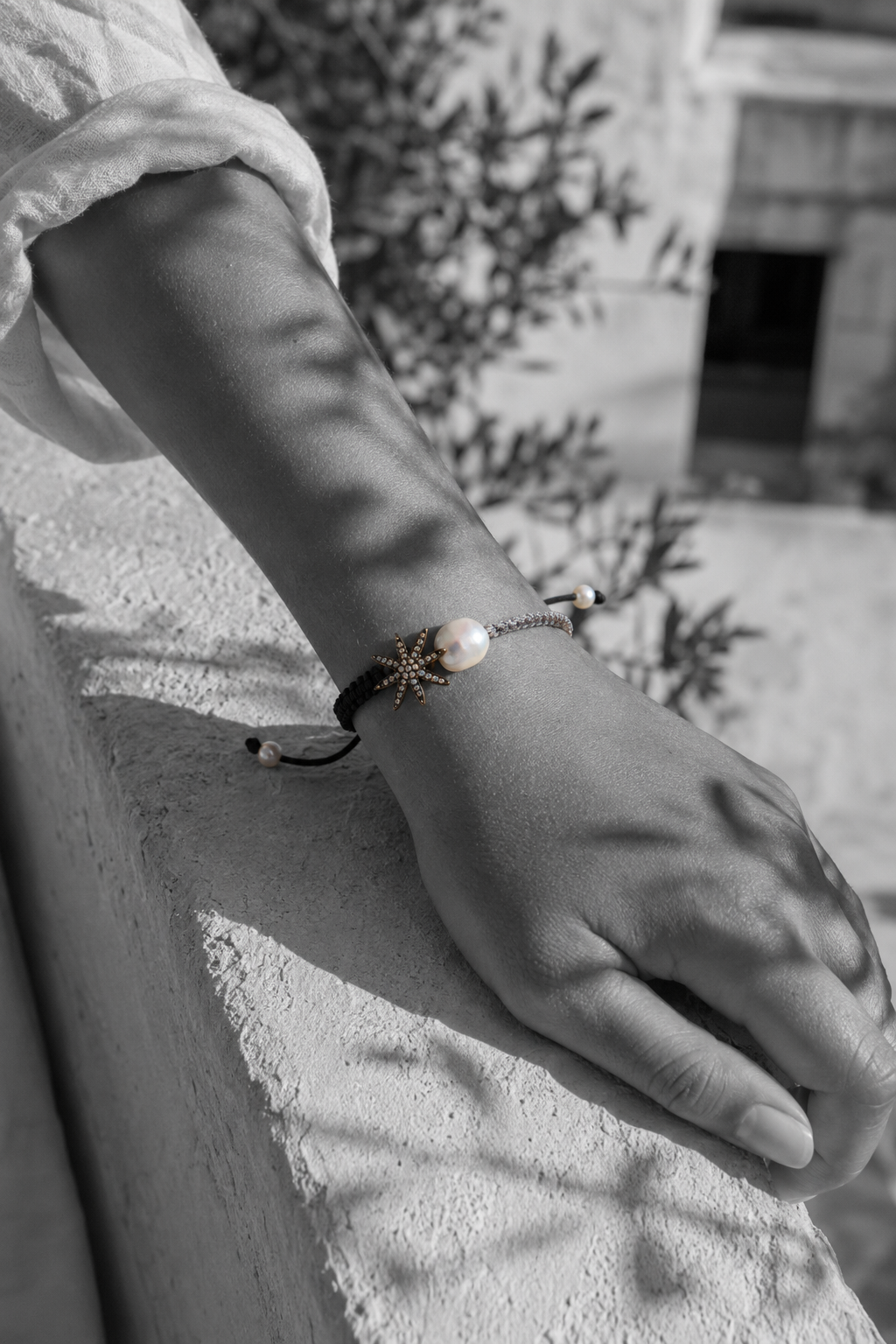 Stella macramé bracelet on wrist — oxidized silver star, baroque pearl, black and grey cord — black and white, Greece
