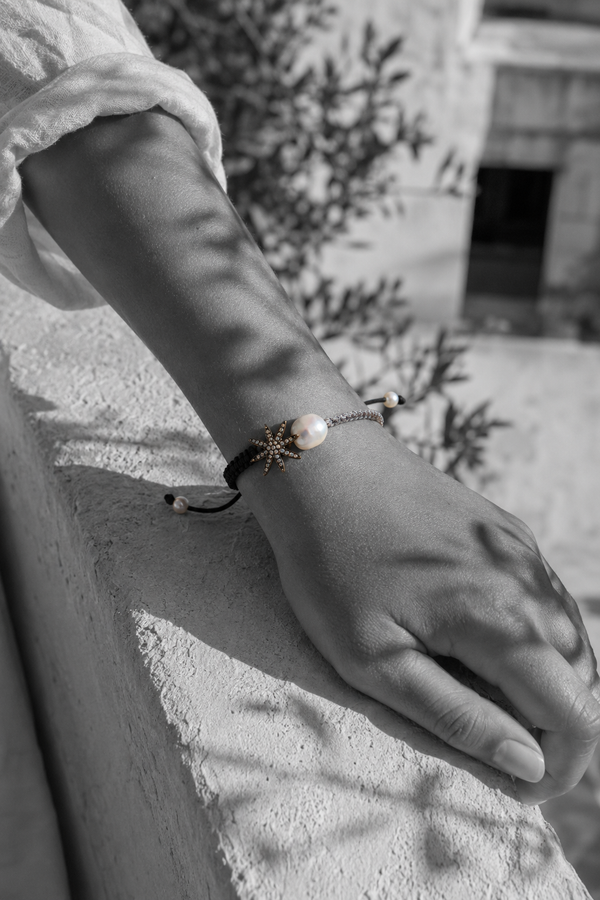 Stella macramé bracelet on wrist — oxidized silver star, baroque pearl, black and grey cord — black and white, Greece