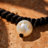 Macro detail of Tara necklace, gold star charms on a pearl with black macramé cord — JLL Pearl